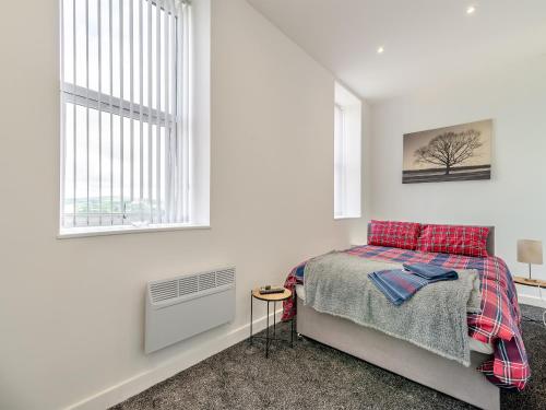 a bedroom with a bed and two windows at Number Four - Uk44899 in Brierfield