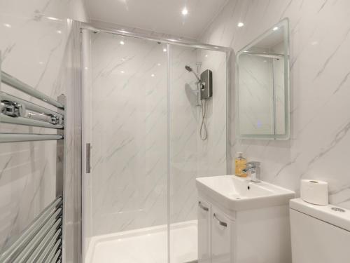a white bathroom with a shower and a sink at Number Three - Uk44900 in Brierfield