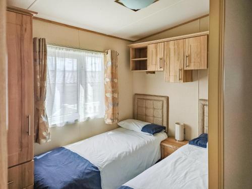 2 camas en una habitación pequeña con ventana en 32 Skelmorlie, en Skelmorlie