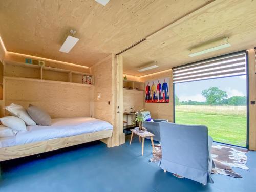 a bedroom in a tiny house with a large window at The Studio in Yatton Keynell