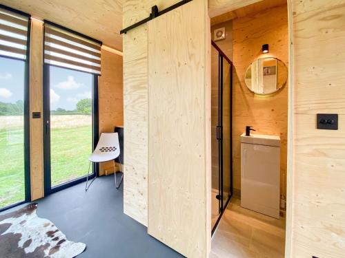 a room with wooden walls and a table and a window at The Studio in Yatton Keynell