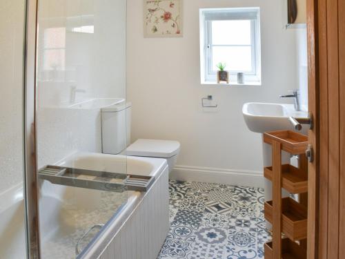a bathroom with a toilet and a sink at Salty Kisses in Mundesley
