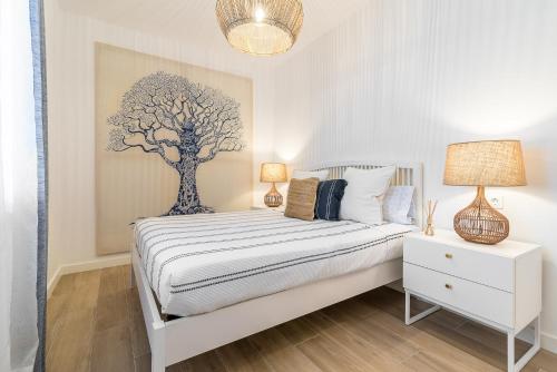 1 dormitorio con 1 cama con una pintura de árbol en la pared en Mirador del Atlántico, en Las Palmas de Gran Canaria