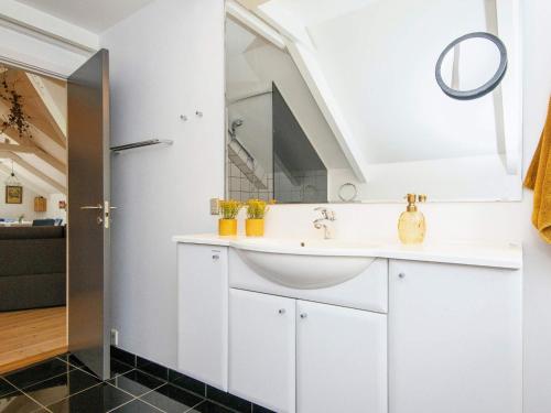 ein Badezimmer mit einem weißen Waschbecken und einem Spiegel in der Unterkunft Bright Cottage with Hot Tub - By Traum Ferienwohnungen in Ebeltoft