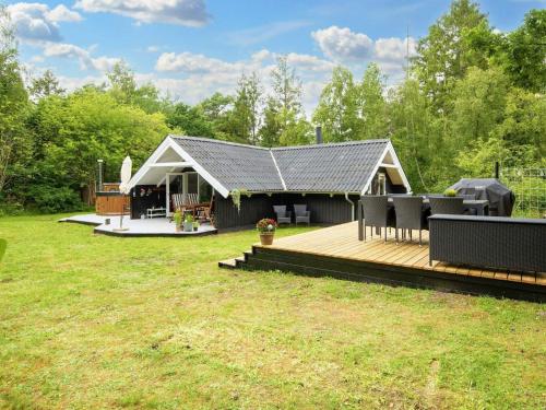 a house with a wooden deck in a yard at Bright Cottage with Hot Tub - By Traum Ferienwohnungen in Ebeltoft