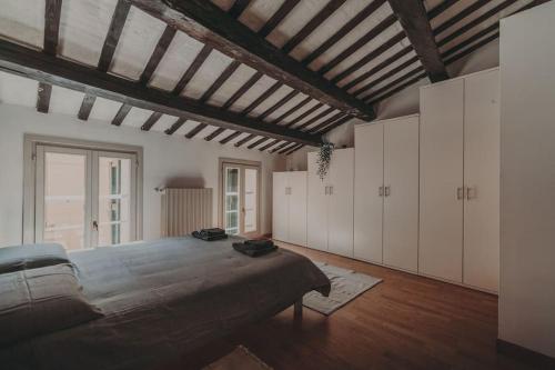 una grande camera da letto con un grande letto e armadi bianchi di [Centro] Casa con parcheggio a Ravenna