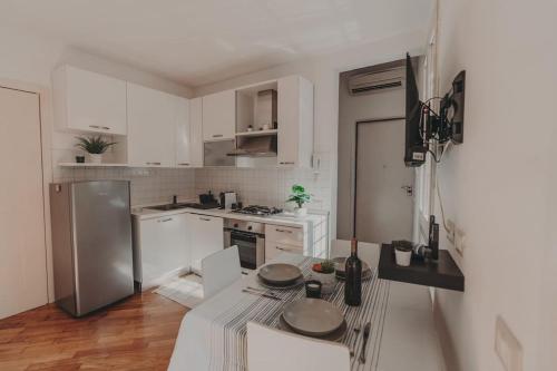 a kitchen with white cabinets and a stainless steel refrigerator at [Centro] Casa con parcheggio in Ravenna