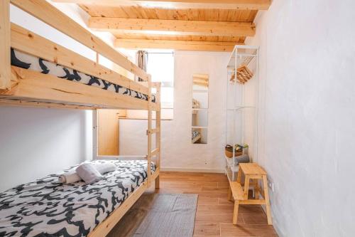 a bedroom with a bunk bed and a desk at Casa Xanoca in Vila do Bispo