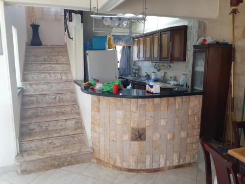 a kitchen with a counter top and a staircase at Paradise villa in Dawwār Ḩalīs