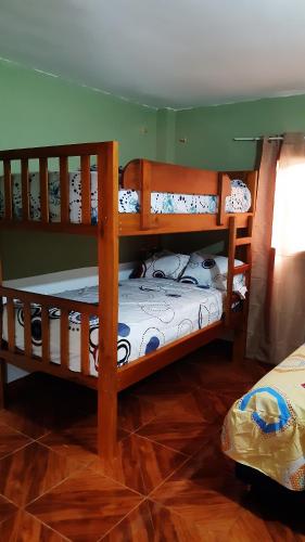 two bunk beds in a room with wood floors at Alojamiento Same in Volcán Chimborazo