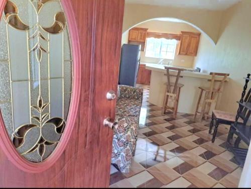 a room with a door and a kitchen at Mango tree Oasis in Treasure Beach