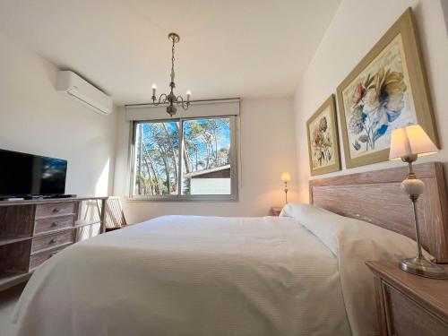 a bedroom with a large white bed and a window at Emerald Apartments - Parrillero exclusivo in Punta del Este