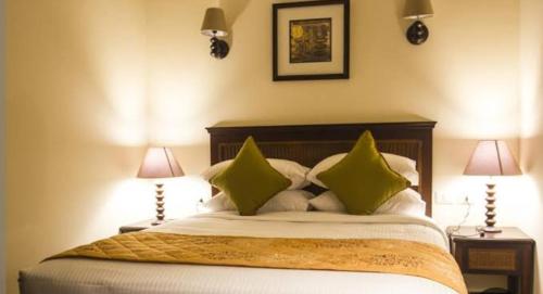 um quarto com uma cama grande e almofadas verdes em Porto Golf Marina - Golf Bay em El Alamein