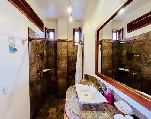 a bathroom with a sink and a shower at Lava Heron Galapagos Apartment in Puerto Ayora