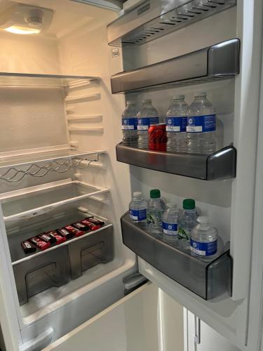 an open refrigerator filled with bottles of water at Luxurious 2 bedroom apartment in Central London in London