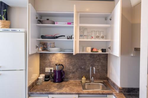 una cocina con armarios blancos y fregadero en Deluxe Residence Istanbul 2 en Estambul