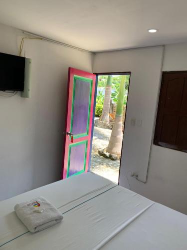 a room with a bed and a colorful door at Hotel Agroturistico Palma Vino in Arboletes