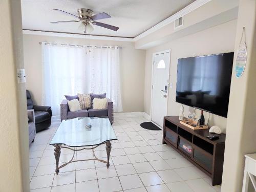 CasaAzul-2605B-Beach & Pleasure Pier a block away في جالفيستون: غرفة معيشة مع أريكة وتلفزيون