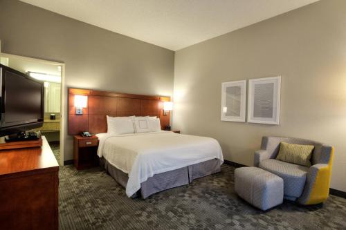 Pokój hotelowy z łóżkiem i krzesłem w obiekcie Courtyard by Marriott McAllen w mieście McAllen