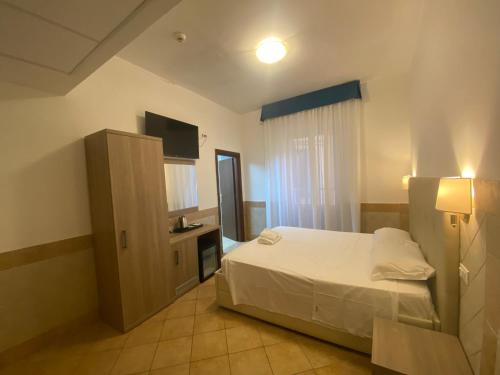 a bedroom with a bed and a cabinet and a television at Hotel Alex Square in Rome