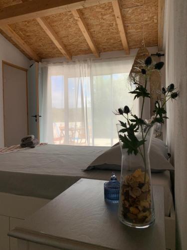 un jarrón con flores en una mesa junto a una cama en Além do Tejo, en Arraiolos