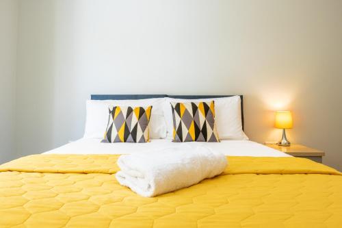 a bedroom with a large yellow bed with two lamps at The Orchard - Spacious 5 Bed in Burton upon Trent