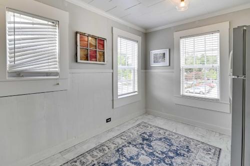 an empty room with two windows and a refrigerator at Cozy Starkville Apartment Walk to Main Street! in Starkville