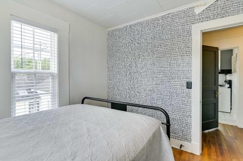 a bedroom with a brick wall and a bed at Cozy Starkville Apartment Walk to Main Street! in Starkville