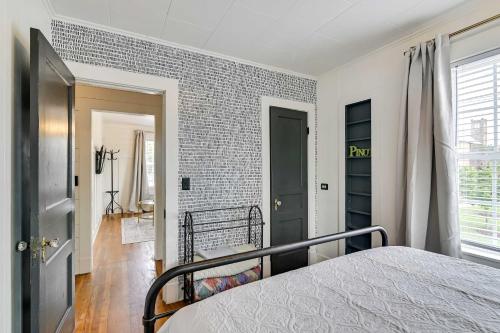 a bedroom with a bed and a brick wall at Cozy Starkville Apartment Walk to Main Street! in Starkville