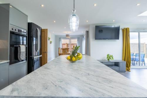 a kitchen with a counter with a bowl of fruit on it at The Orchard - Spacious 5 Bed in Burton upon Trent