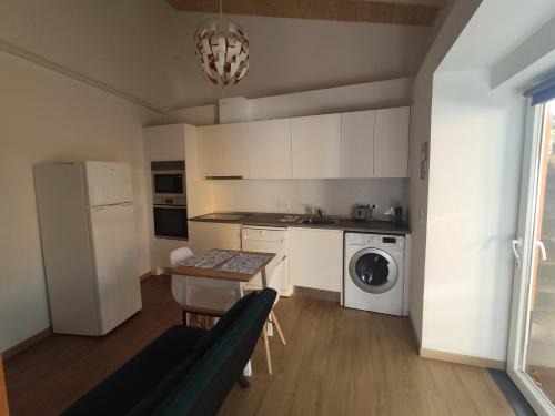 a kitchen with a couch and a table and a refrigerator at Quinta das Bicas AL in Angra do Heroísmo