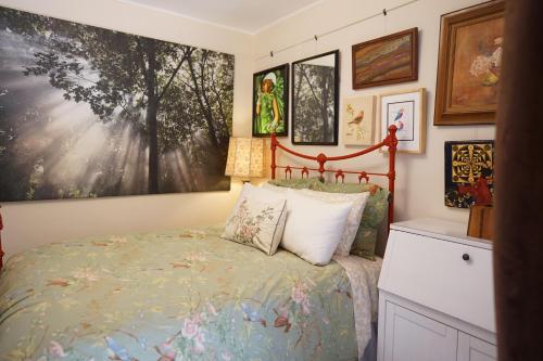 um quarto com uma cama e pinturas na parede em Perfect Location - 4BD,1BA - Restored Redwood Home em São Francisco