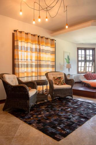 a living room with two chairs and a couch at Villa Bella Ferradura in Búzios