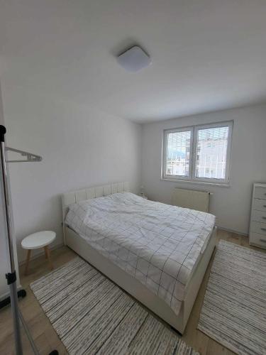 - une chambre blanche avec un lit et 2 fenêtres dans l'établissement Sarajevo Apartments, à Sarajevo