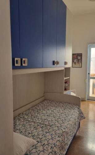 1 dormitorio con 1 cama con armarios azules en Grotta verde Marina di andrano, en Andrano