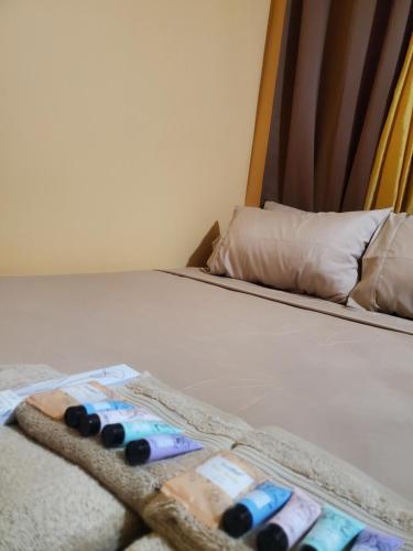 a close up of a bed with some remotes on it at K&L Private Room Suites in Arima