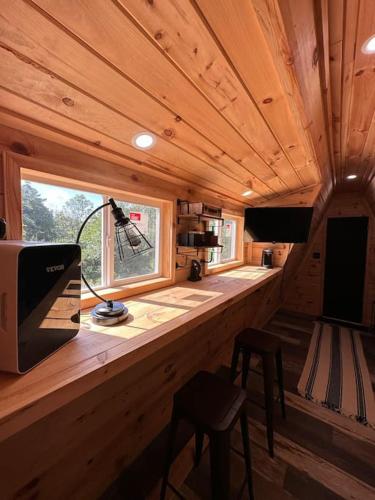 a wooden room with a counter with a television and a window at Acres Away in Penn Yan