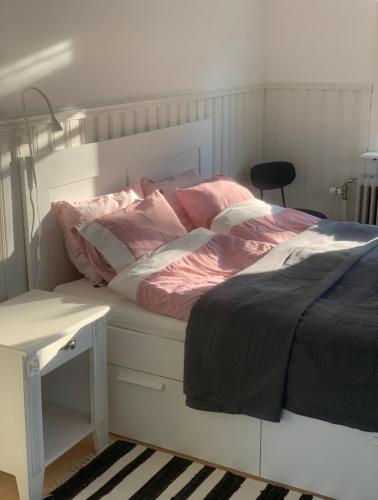 ErikslundにあるGotellのベッドルーム1室(ピンクのシーツが入った白いベッド1台、デスク付)