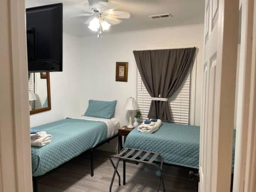 Duas camas num quarto com uma televisão e uma janela em Comfort & Quiet in a central location em Elizabeth City