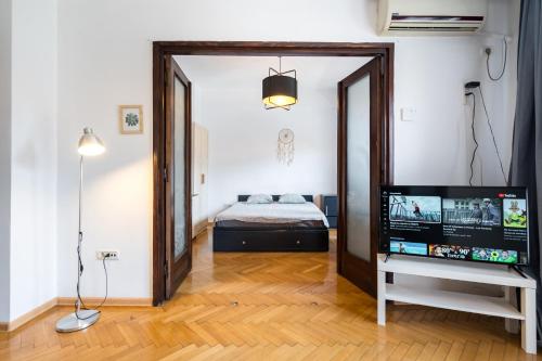 een kamer met een bed, een televisie en een spiegel bij Sleek Comfort - A Blend of Style and Convenience in Boekarest