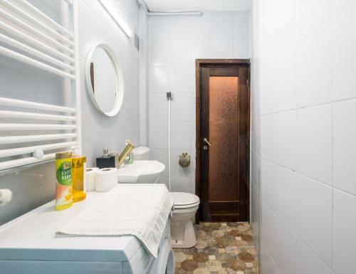 een witte badkamer met een toilet en een wastafel bij Sleek Comfort - A Blend of Style and Convenience in Boekarest