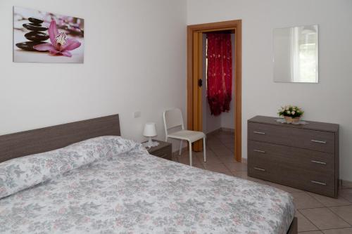 a bedroom with a bed and a dresser and a chair at Casa Vacanze Relax in Agropoli
