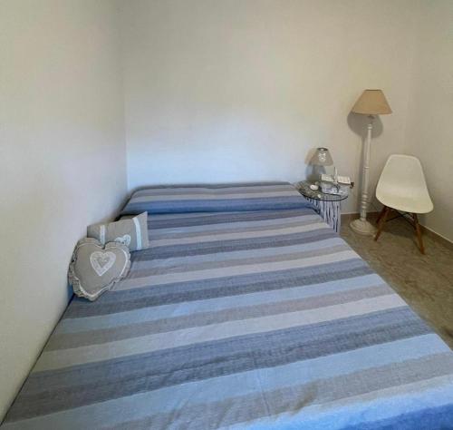 a bedroom with a large bed with a striped blanket at Casa Frontemare in Carloforte