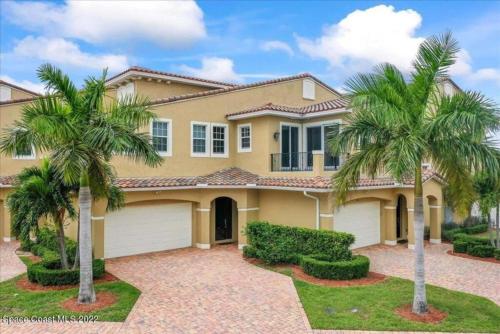 a large house with palm trees in front of it at Luxury Villa near beach in Indian Harbour Beach