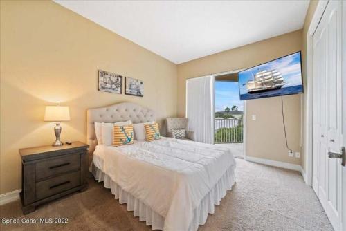um quarto com uma cama e uma grande janela em Luxury Villa near beach em Indian Harbour Beach