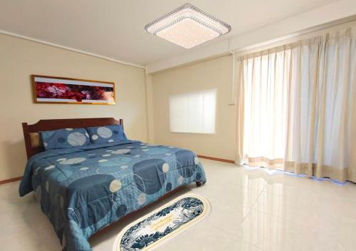 a bedroom with a blue bed and a window at Sea Hill Phatamnak Pattaya in Pattaya South
