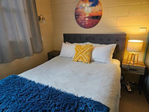 a bedroom with a bed with a blue blanket on it at Di's B&B in Matamata