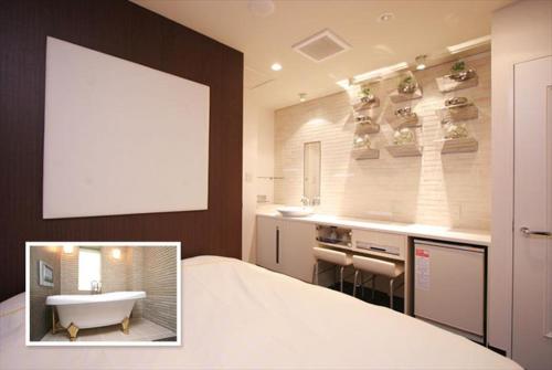 uma casa de banho com uma banheira e um lavatório e uma banheira em HOTEL DCUBE em Tóquio