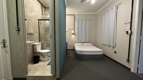 a room with a bathroom with a toilet and a sink at Suíte nº 11 - Praia das Pitangueiras in Guarujá