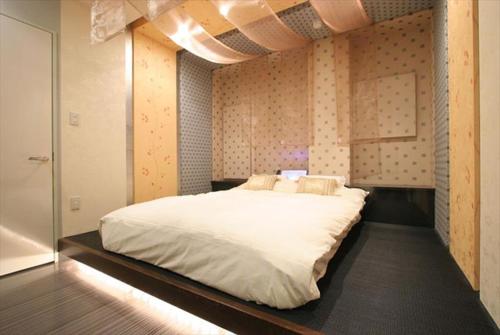 ein Schlafzimmer mit einem großen weißen Bett in einem Zimmer in der Unterkunft HOTEL DCUBE in Tokio